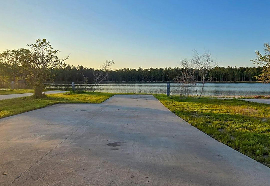 Full-hookup lakefront RV site in warm evening light at Lake LaCroix RV Resort — ideal for monthly and snowbird stays